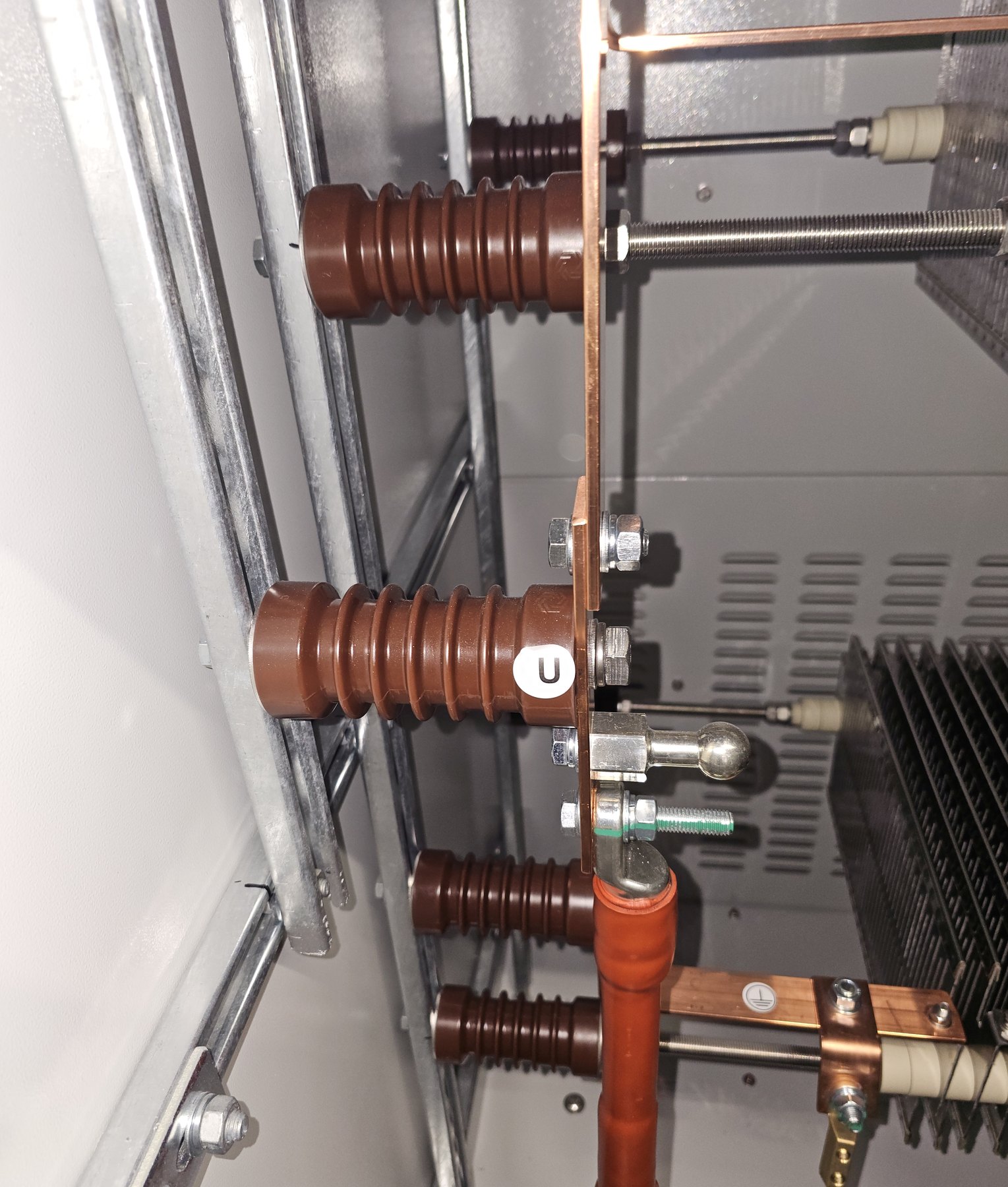 COM.SAR IT Cleaning project photograph: brown insulators supporting copper bars inside an installation. COM.SAR IT Cleaning project photograph: brown insulators supporting copper bars inside an installation.