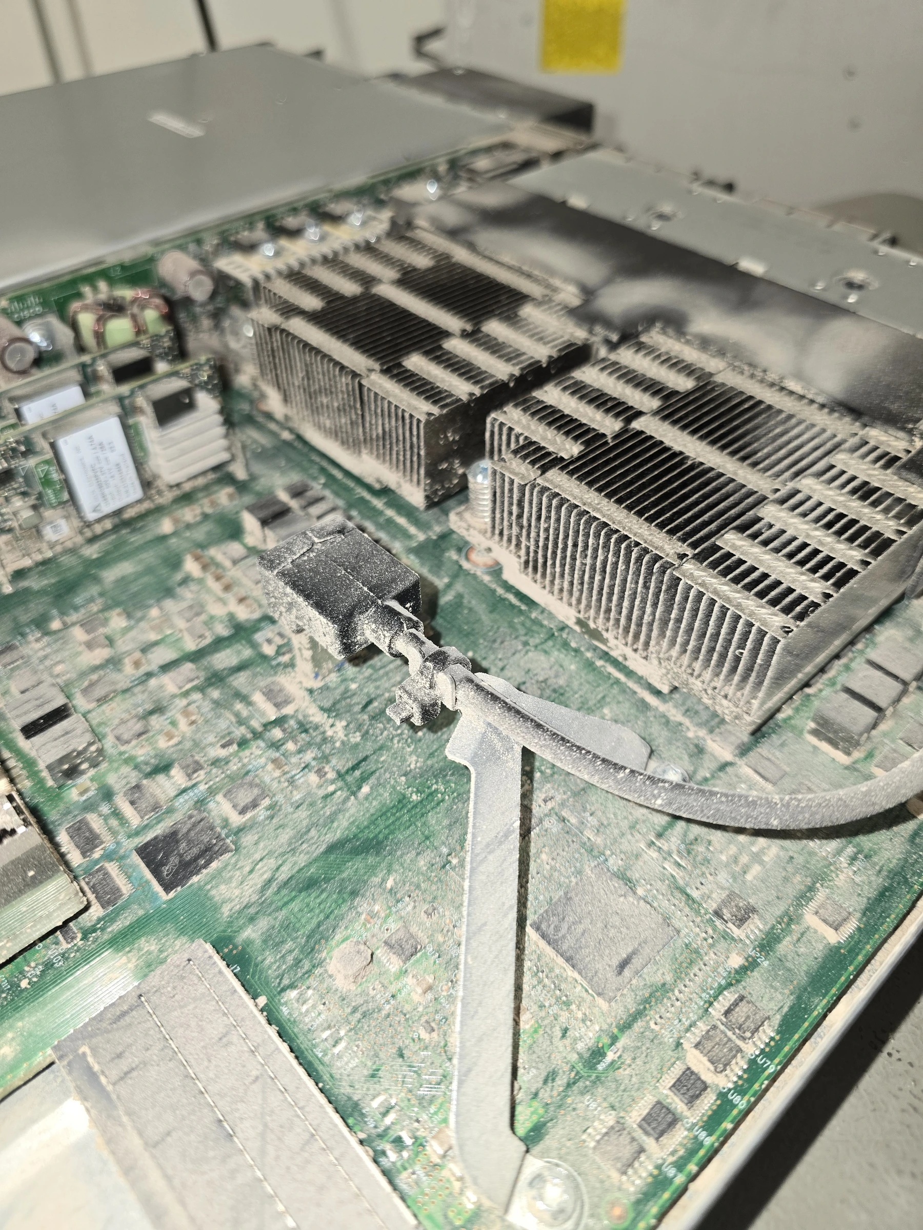 Detailed cleaning of heat sinks and adjacent circuit board surfaces, before cleaning with heavy dust deposits.