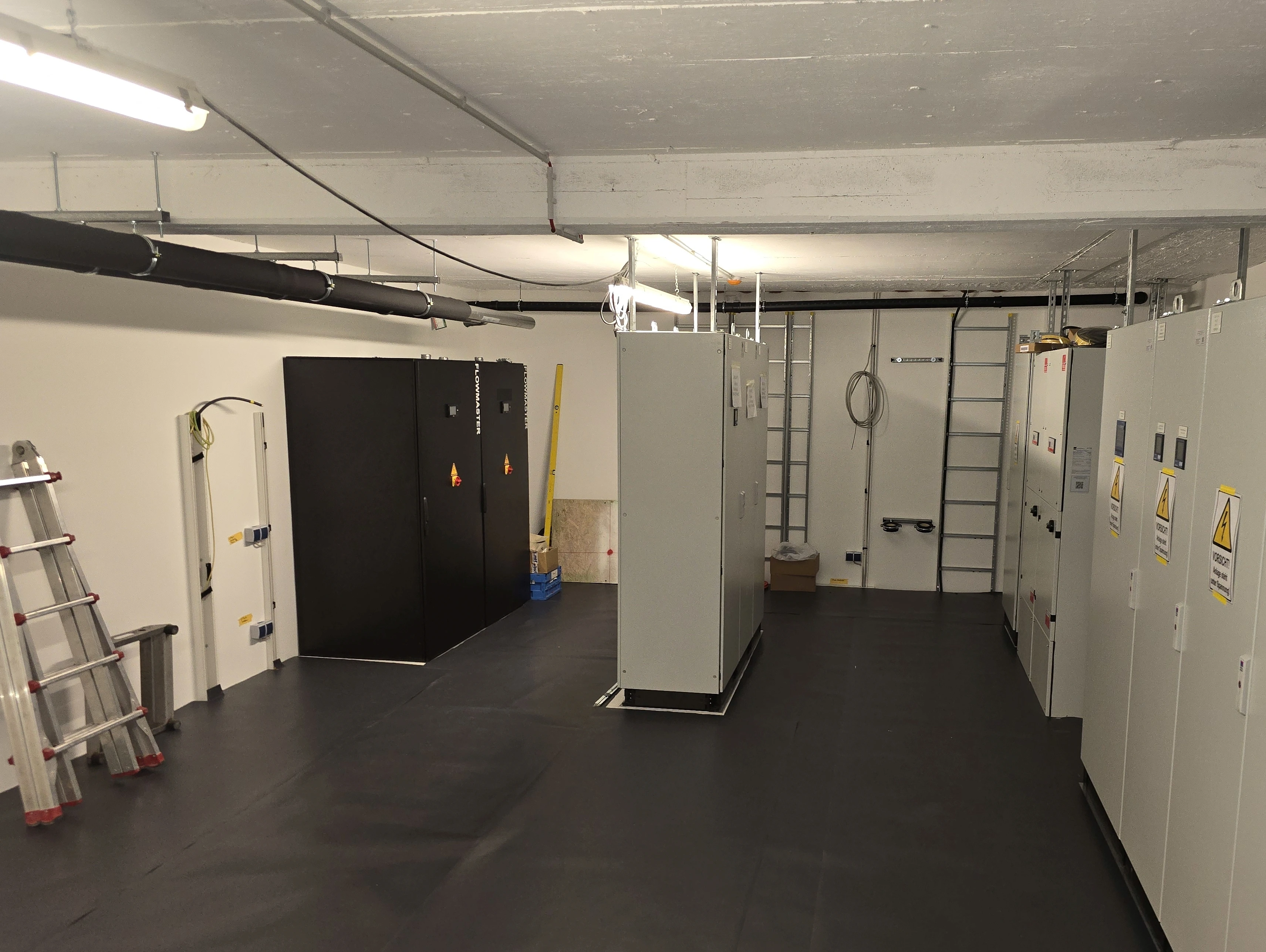 Technical room with protective covering over the cleaned floor between electrical cabinets.