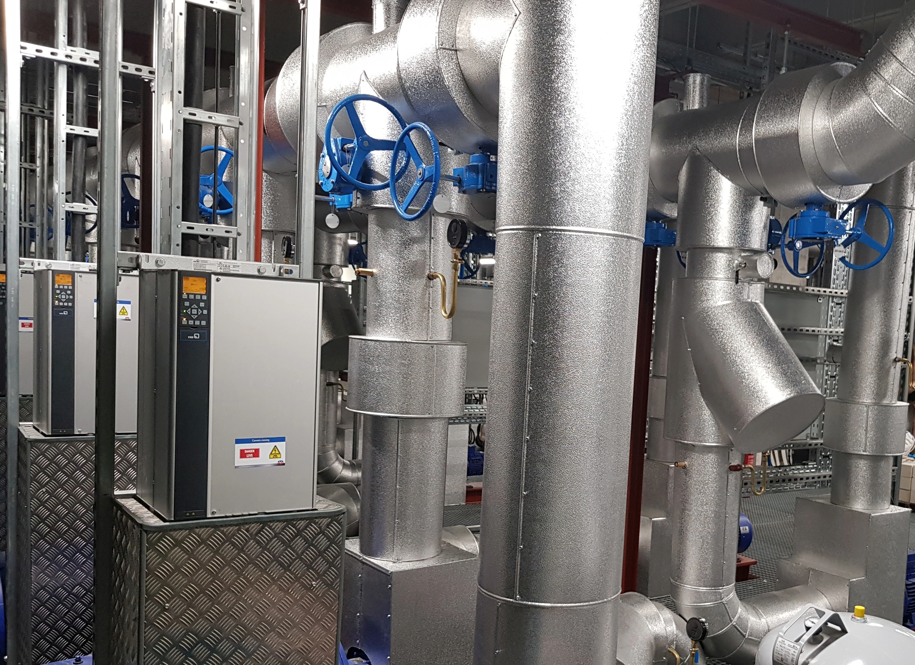 Pump room with insulated pipework, blue handwheels, valves and drive cabinets. Pump room with insulated pipework, blue handwheels, valves and drive cabinets.
