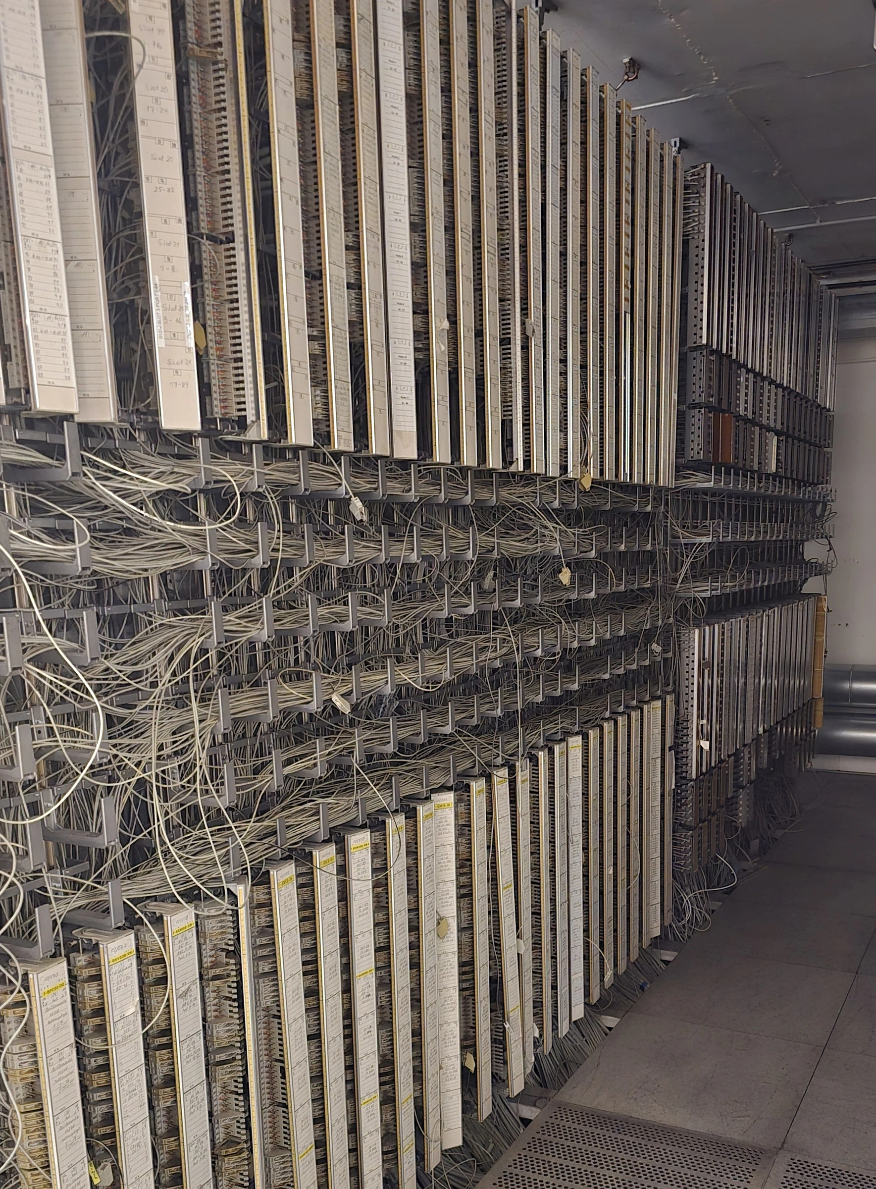 Telefonverteilung mit beschrifteten Anschlussleisten und dicht belegten Rangierfeldern.