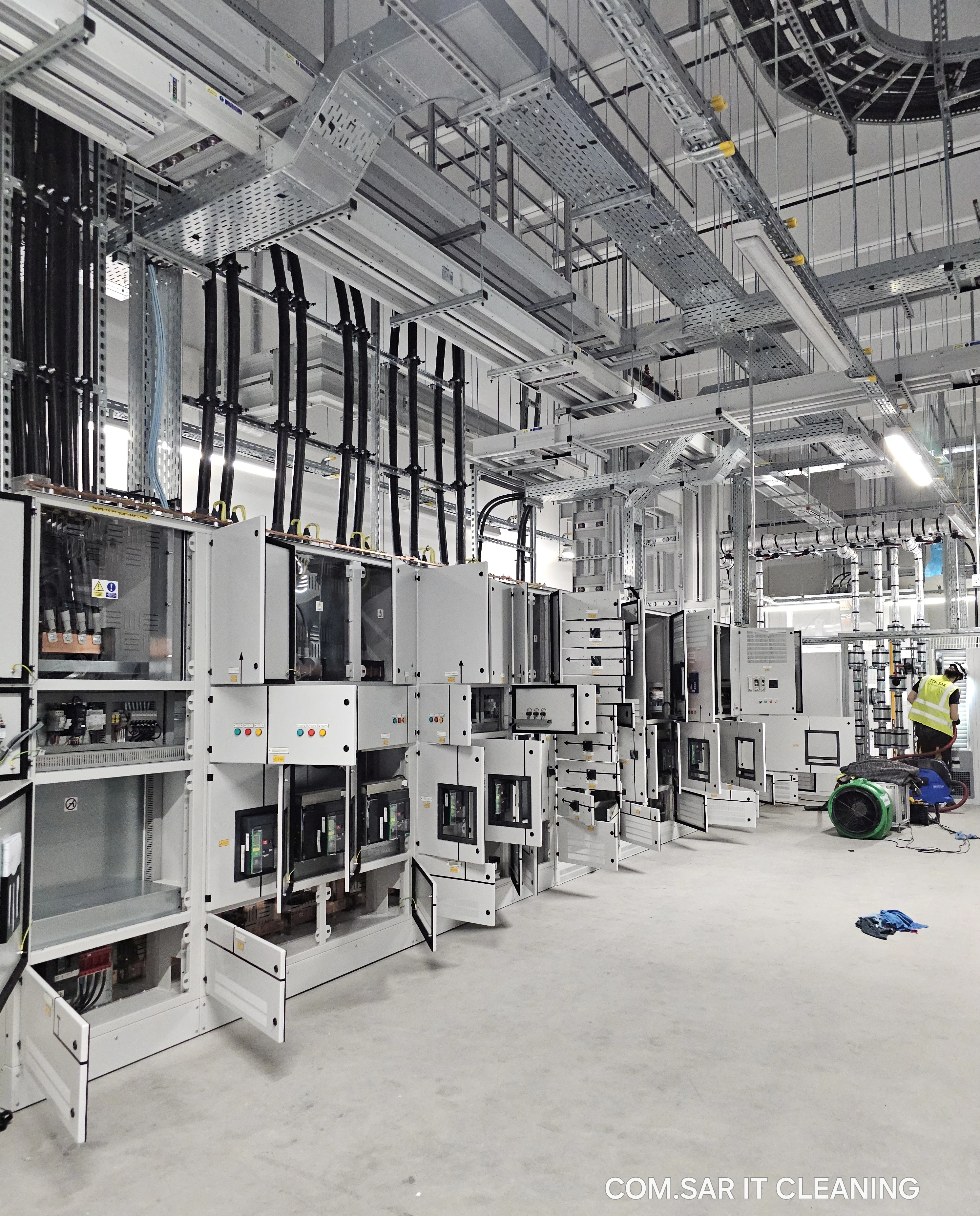Open switchgear compartments during interior cleaning, with a team member using a cleaning hose on the right. Open switchgear compartments during interior cleaning, with a team member using a cleaning hose on the right.