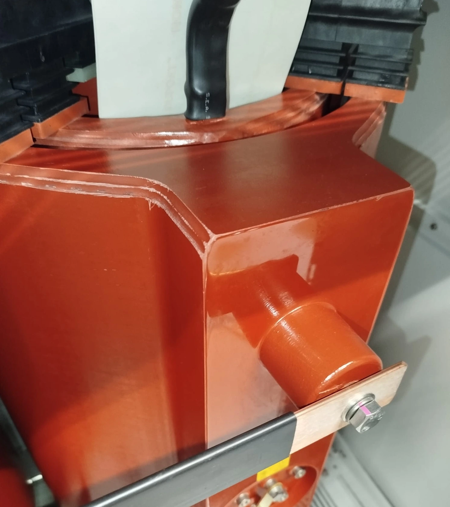 Close-up of a transformer winding with a cast-resin surface and connection. Close-up of a transformer winding with a cast-resin surface and connection.